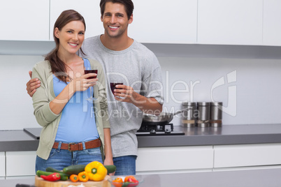 Delighted couple clinking their glasses of red wine