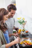 Couple cooking together vegetables