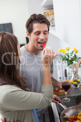 Woman feeding her husband bell pepper