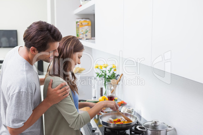 Man looking at his wife cooking