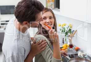 Attractive woman feeding her husband bell pepper