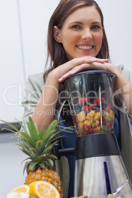 Attractive woman leaning on her blender