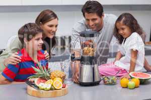Smiling family using a blender