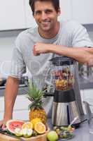 Attractive man leaning on his blender