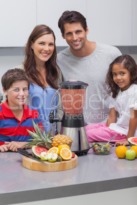 Smiling family using a blender together