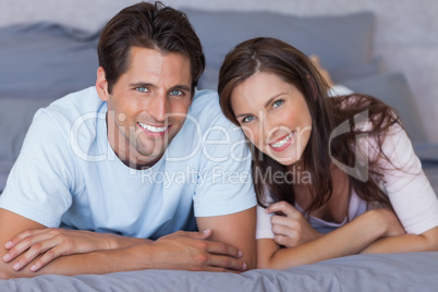 Delighted couple lying on bed
