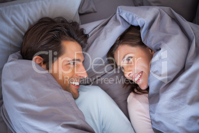 Couple having fun wrapped in their blanket