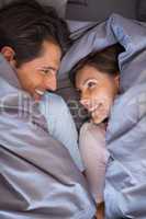 Lovely couple having fun wrapped in their blanket