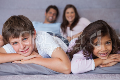 Smiling brother and sister lying on the bed