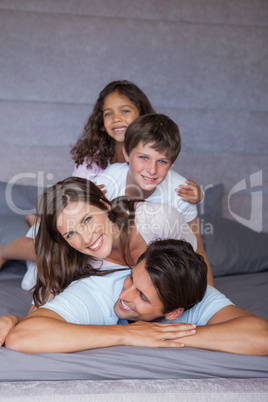 Smiling family playing together on the bed