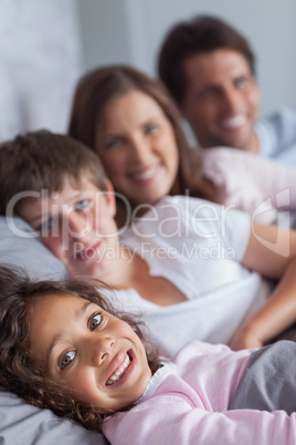 Happy family lying in the bed
