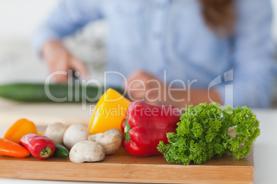 Wooden board with vegetables on a table