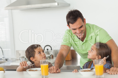 Father talking to his children while they are having breakfast