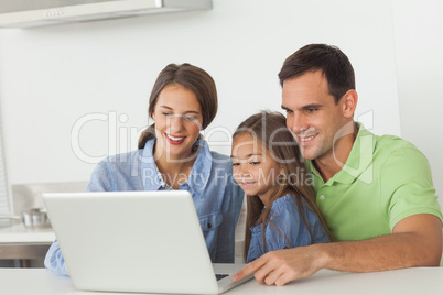 Family using a laptop on the kitchen table