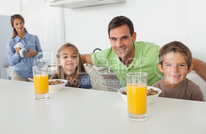 Portrait of a father and his children having breakfast