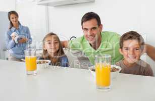 Portrait of a father and his children having breakfast