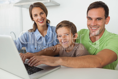 Family using a laptop in the kitchen