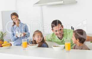 Father speaking to his children who are having breakfast