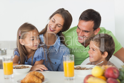 Parents having breakfast with their children