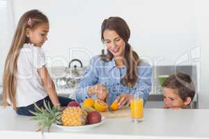 Woman cutting an orange for her children