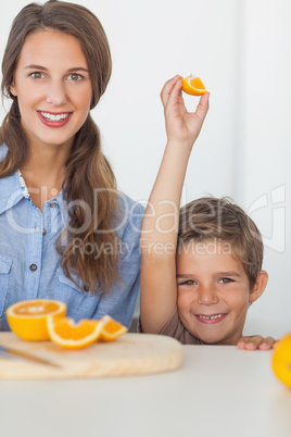 Little boy raising an orange segment