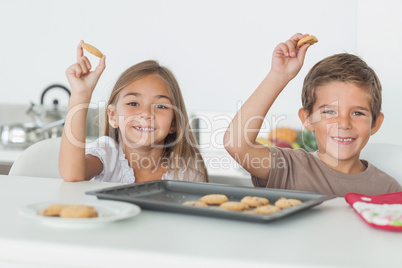 Siblings raising homemade cookies