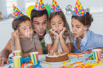 Family blowing candles together