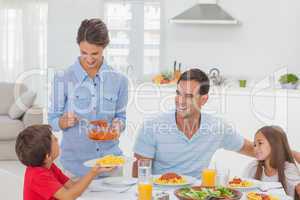 Woman giving pasta sauce to her son