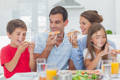 Happy family eating pizza slices