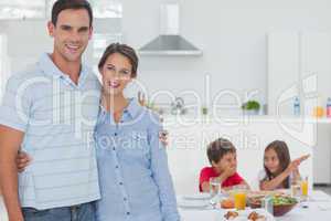 Couple standing in front of children at the table