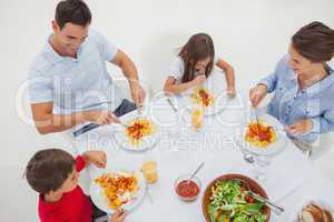 Overview of a family eating pasta with sauce and salad