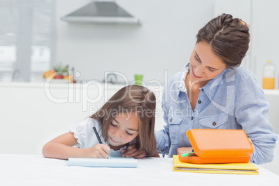 Mother looking at her daughter drawing