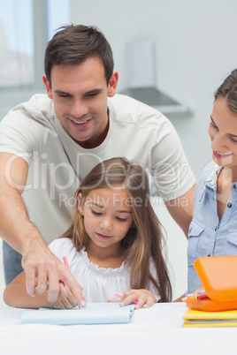Father helping his daughter to draw