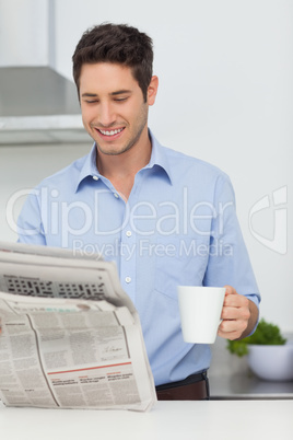 Man with a cup of coffee reading a newspaper