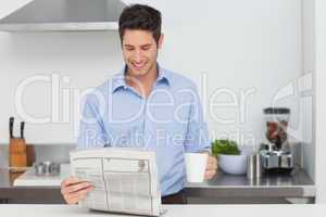 Man reading a newspaper in the kitchen