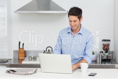 Man using a laptop pc in the kitchen