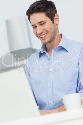 Man using a laptop computer in the kitchen