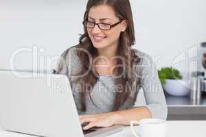 Woman using her laptop in the kitchen