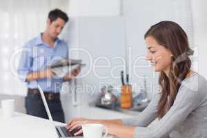 Attractive woman using her laptop in the kitchen