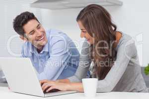 Couple using a laptop in the kitchen