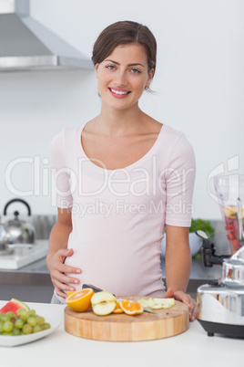 Pregnant woman preparing a fruit cocktail