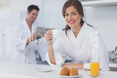 Woman with a dressing gown having breakfast