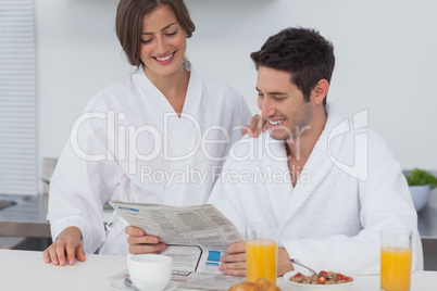 Man reading a newspaper while having breakfast