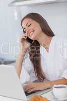 Woman using her laptop while she is phoning