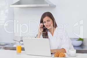 Woman phoning and using a laptop