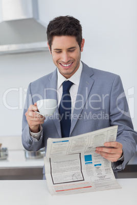 Businessman reading a newspaper and drinking a coffee
