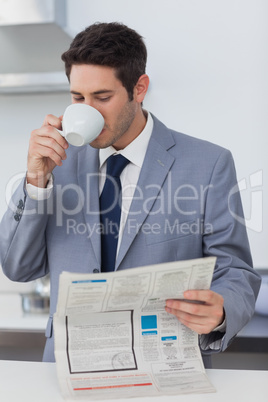 Businessman drinking a coffee and reading a newspaper
