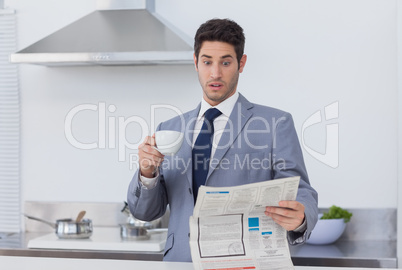 Businessman being astonished when reading the news