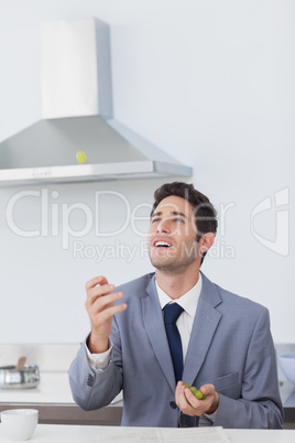 Businessman throwing grape in the air