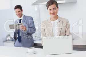 Businesswoman using a laptop while having breakfast